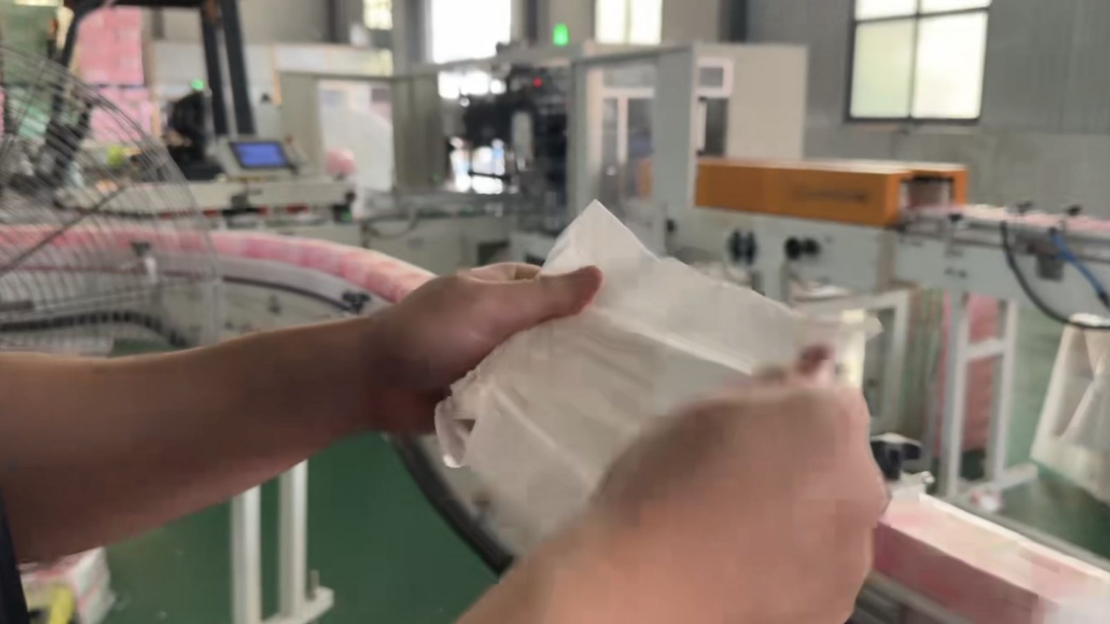Factory worker handling paper sheets in production