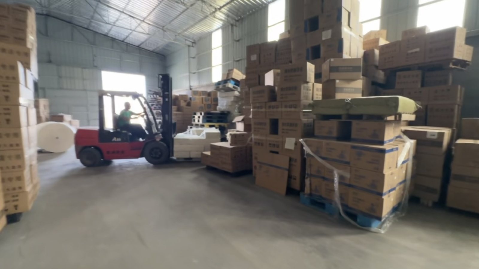 Forklift operator moving inventory in a warehouse